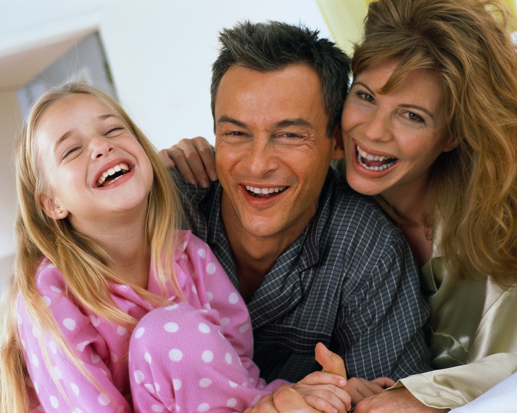 Happy Family Laughing in Bed